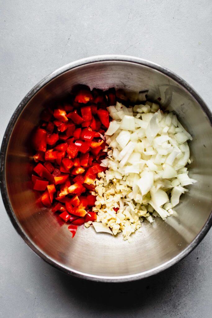 Red pepper and onions in large bowl.