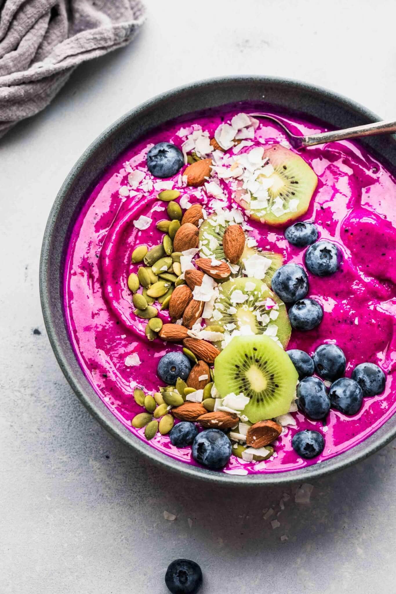 Dragon Fruit Smoothie Bowl topped with blueberries, coconut, almonds, kiwi and pumpkin seeds.