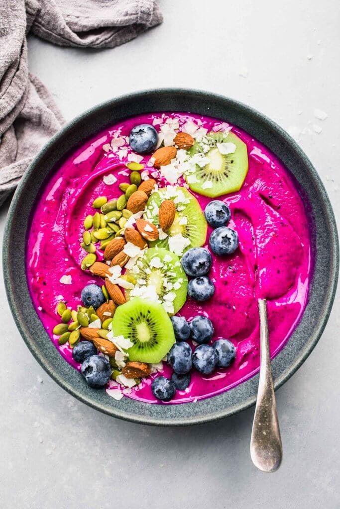 Dragon Fruit Smoothie Bowl topped with blueberries, coconut, almonds, kiwi and pumpkin seeds.