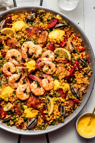 Paella next to bowl of aioli.