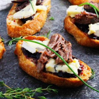 These Short Rib Crostini with Cambozola Cheese and Cherry Jam make a perfect appetizer that's as suitable for elegant entertaining as it is for football tailgating | platingsandpairings.com