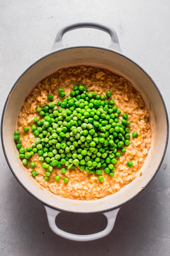 Peas being stirred into risotto. 