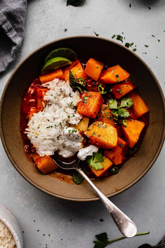 Overhead shot of potato vindaloo with rice and greek yogurt.