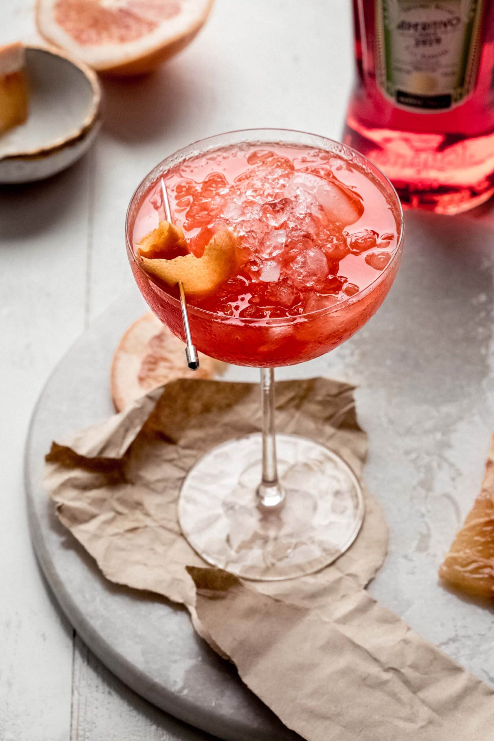 Grapefruit spritz in coupe garnished with grapefruit twist.