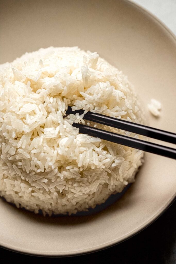 Chopsticks in bowl of rice.