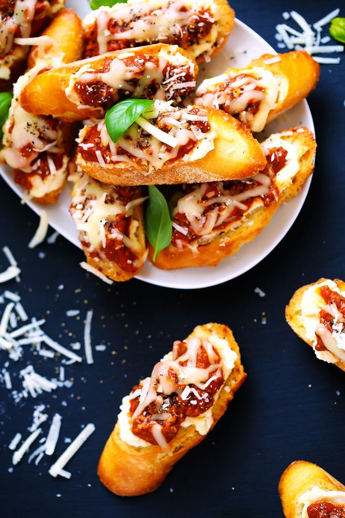 These Lasagna Crostini are a perfect make ahead party appetizer. The Italian meat sauce, creamy ricotta and melty mozzarella cheese are irresistible. Pair them with Chianti for a delicious treat! | platingsandpairings.com