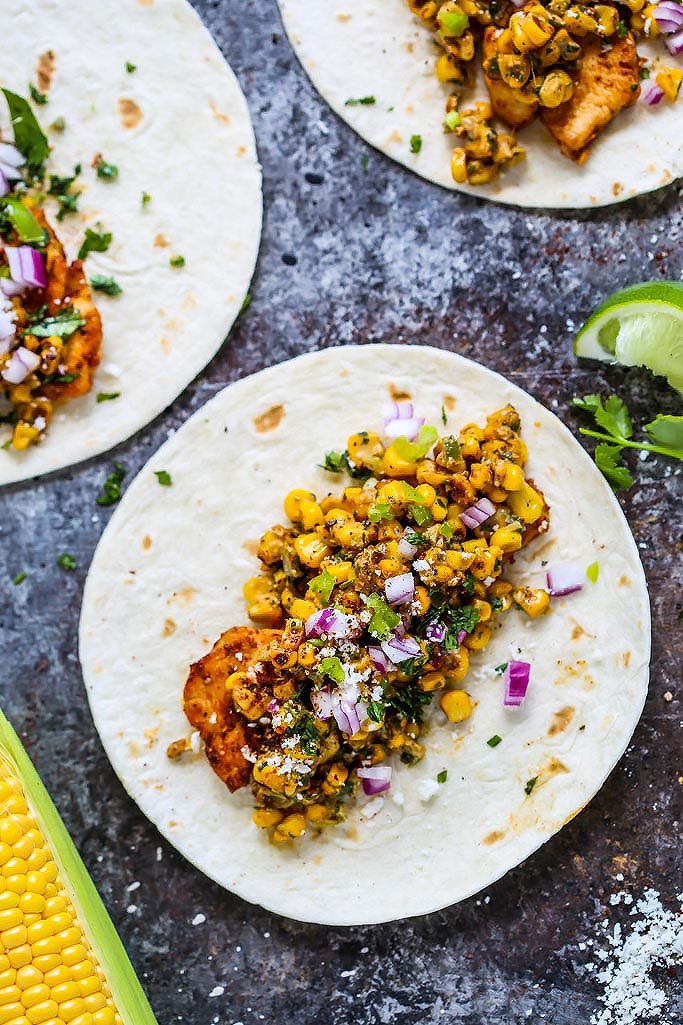 These Mexican Street Corn Chicken Tacos put a fun twist on elotes or grilled Mexican corn on the cob that's slathered in a tangy cream sauce and sprinkled with chili powder. Plus, they come together in just 20 minutes! | platingsandpairings.com