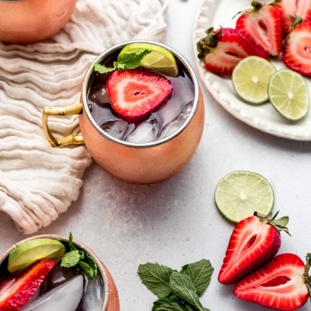 Three strawberry moscow mules on counter.