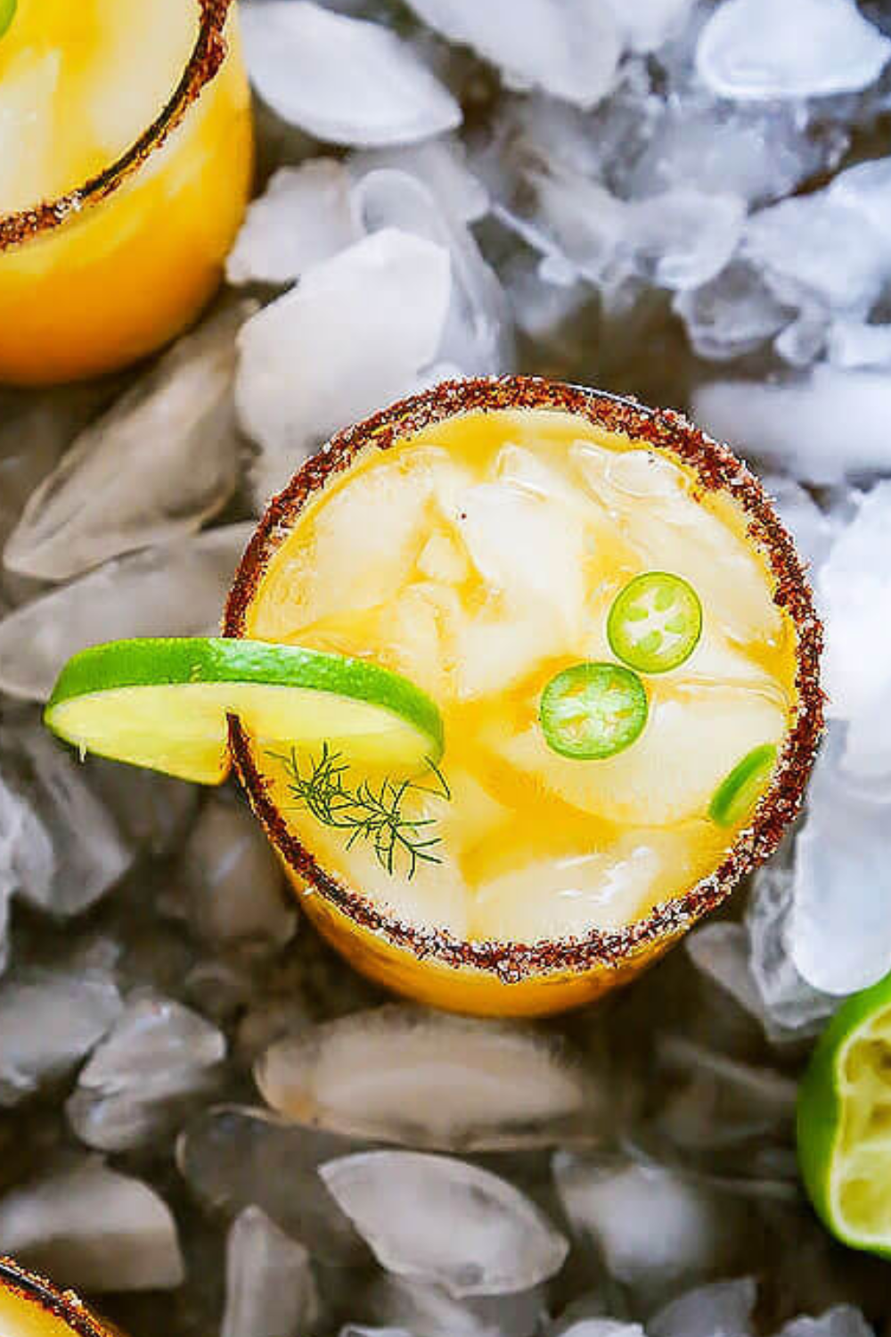 Close up of chili salt rimmed mango michelada in glass with ice.