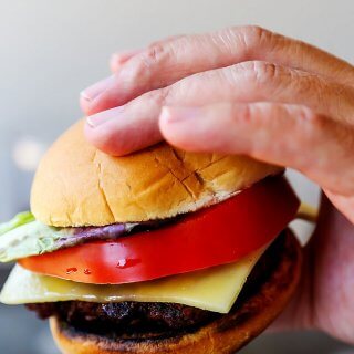 These Red Wine Burgers are decadent treat for your summer BBQ. Seasoned with a red wine-shallot reduction, topped with melted cheese and served simply with a thick slice of tomato and lettuce. | platingsandpairings.com