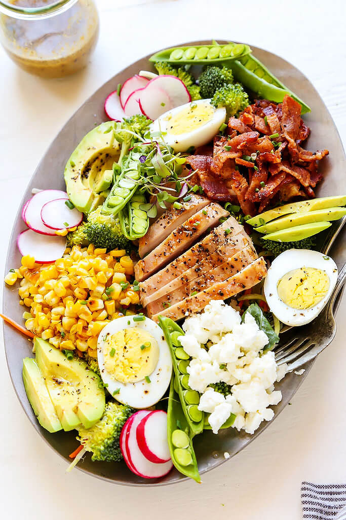 This Summer Chicken Cobb Salad is loaded with veggies and topped with grilled chicken, corn, bacon, avocado, hard boiled egg and goat cheese. | platingsandpairings.com