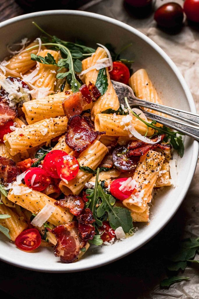 Close up shot of prepared blt pasta in white bowl. 