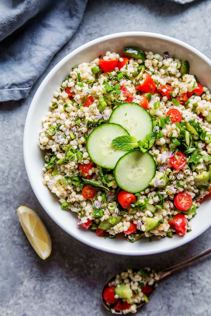 This Israeli Couscous Tabbouleh Salad recipe combines pearl couscous with tomatoes, cucumber, fresh herbs and a light citrus dressing. It's a perfect make-ahead salad recipe! | platingsandpairings.com