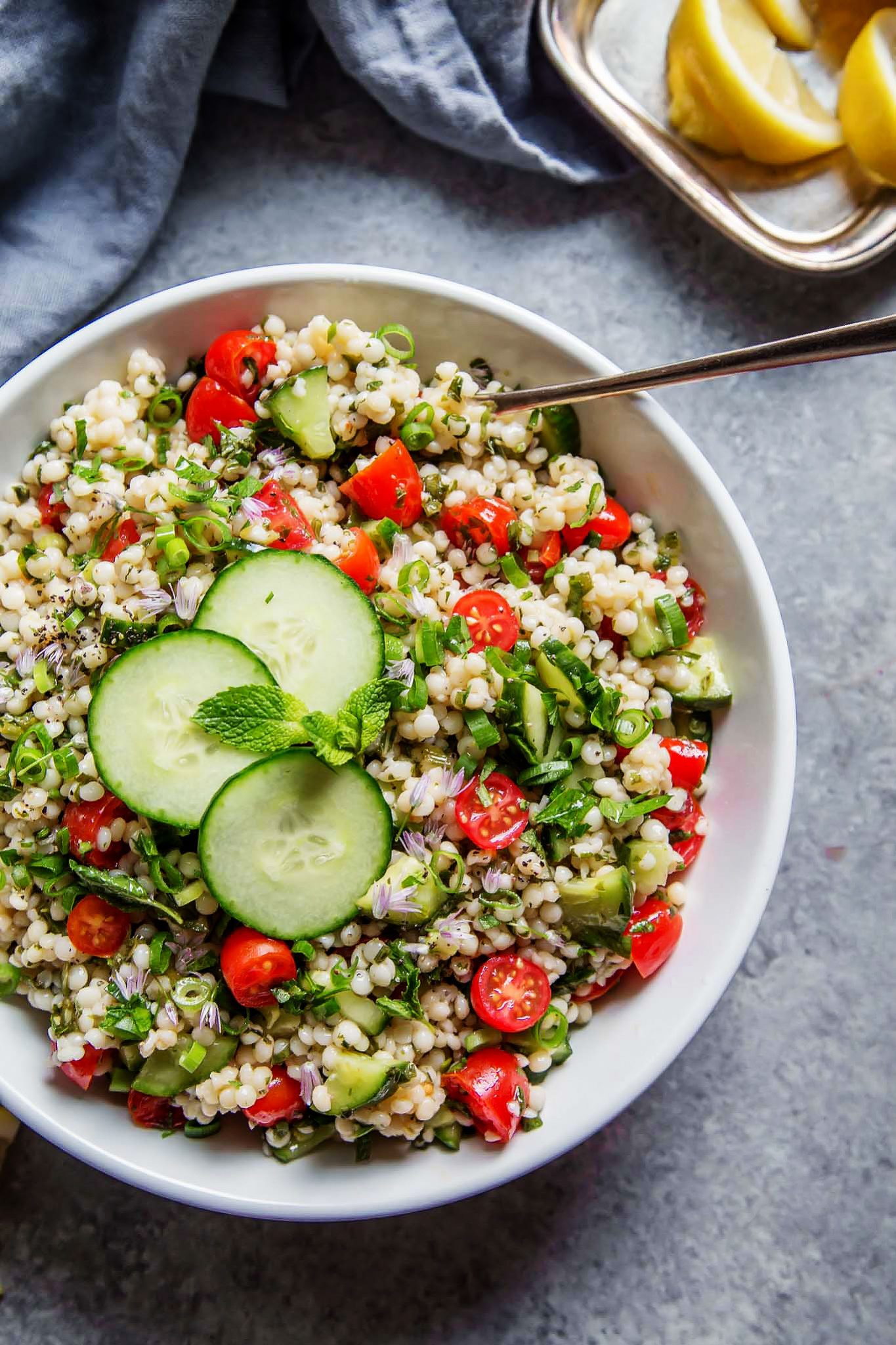 This Israeli Couscous Tabbouleh Salad recipe combines pearl couscous with tomatoes, cucumber, fresh herbs and a light citrus dressing. It's a perfect make-ahead salad recipe! | platingsandpairings.com