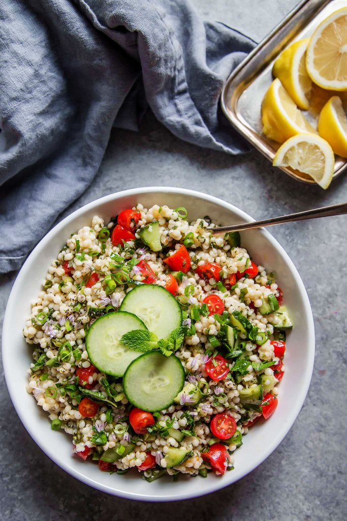 This Israeli Couscous Tabbouleh Salad recipe combines pearl couscous with tomatoes, cucumber, fresh herbs and a light citrus dressing. It's a perfect make-ahead salad recipe! | platingsandpairings.com