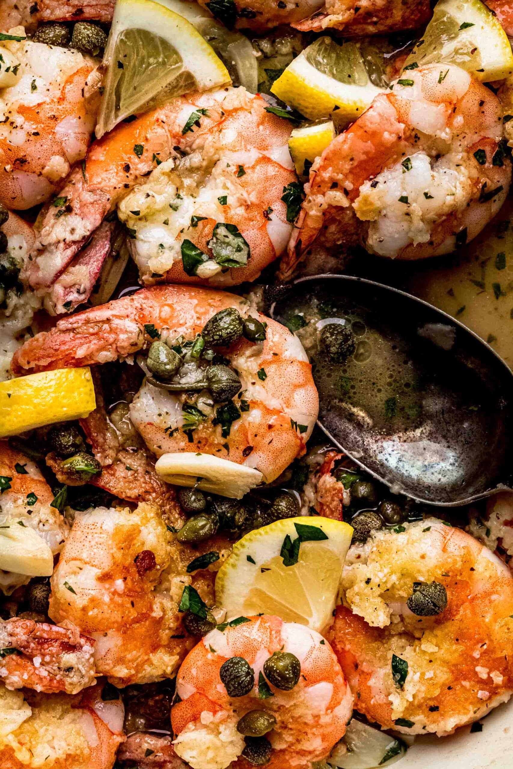 Overhead close up of shrimp piccata flecked with capers.