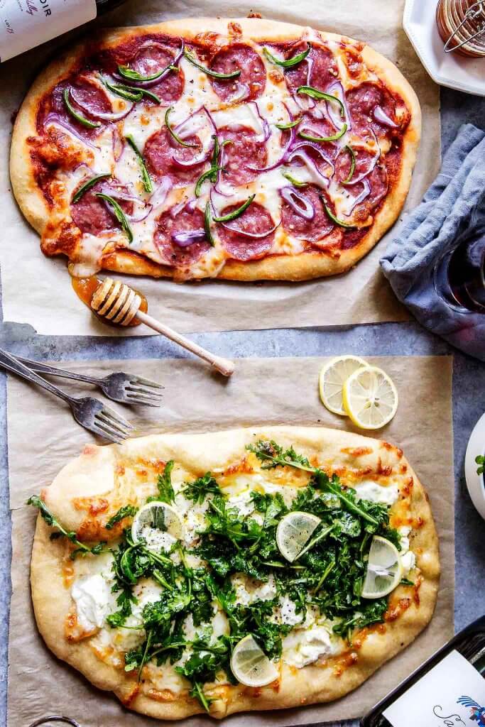 Learn how to host a wine & pizza party at home with these two simple pizza recipes. One features salami, jalapeno & honey and the other is a white pizza topped with goat cheese & arugula salad.