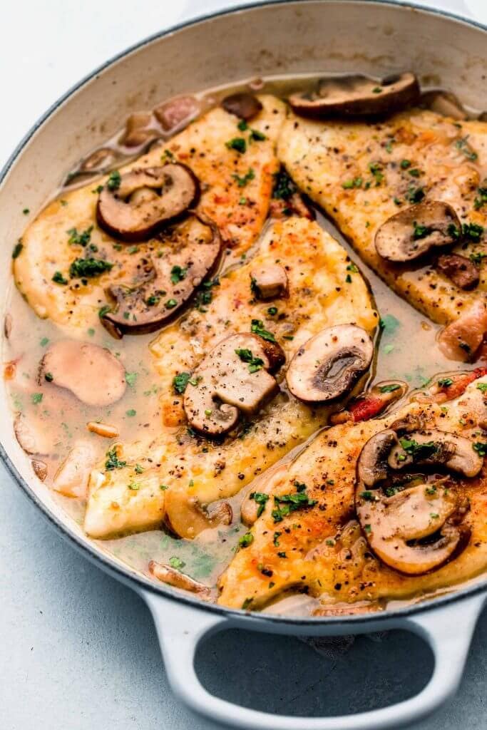 Side view of chicken marsala in skillet. 