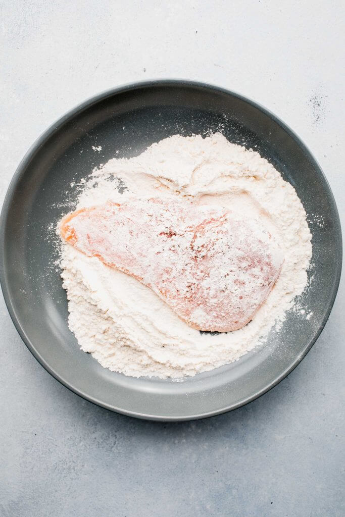 Chicken cutlets dredged in flour. 