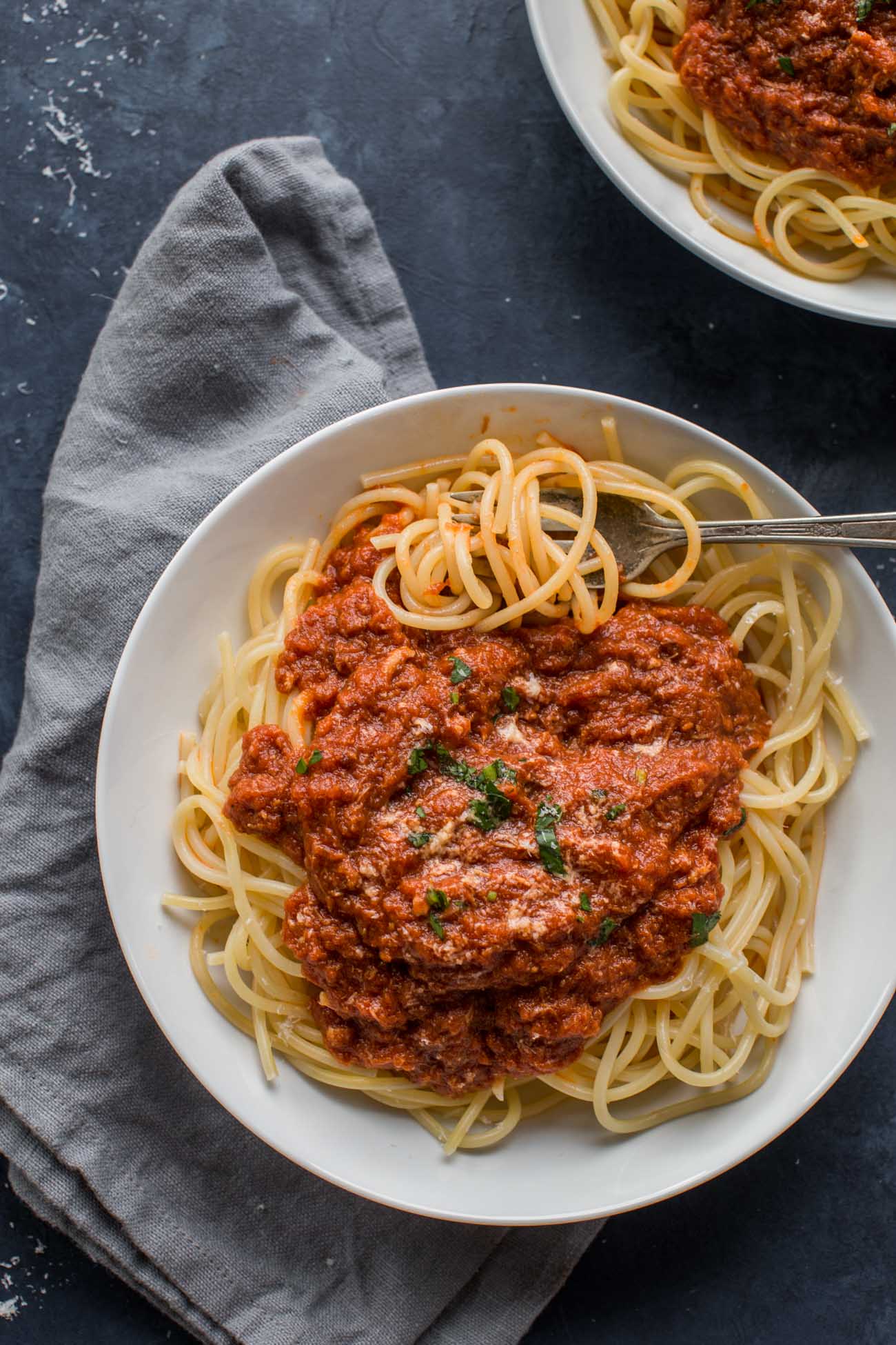 Overhead shot of two bowls of Instant Pot Sunday Gravy served over spaghetti.