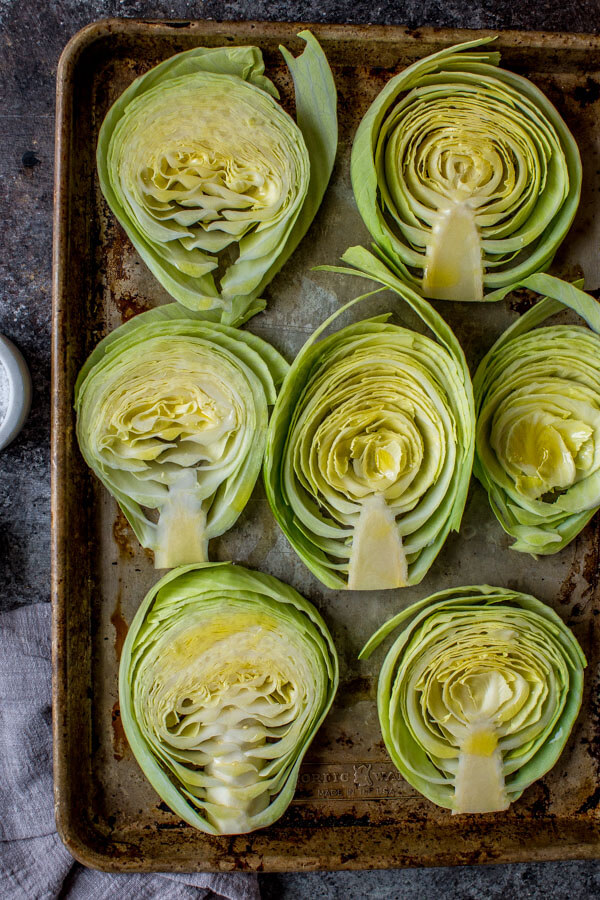 Slices of cabbage arranged on cookie sheet. 