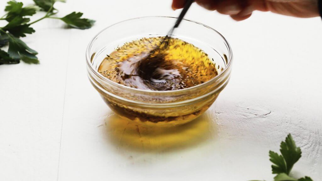 Dressing being whisked together in bowl.