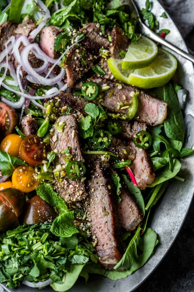 Thai beef salad closeup on silver platter.