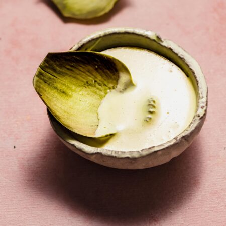 Artichoke leaf dipped into artichoke dipping sauce.