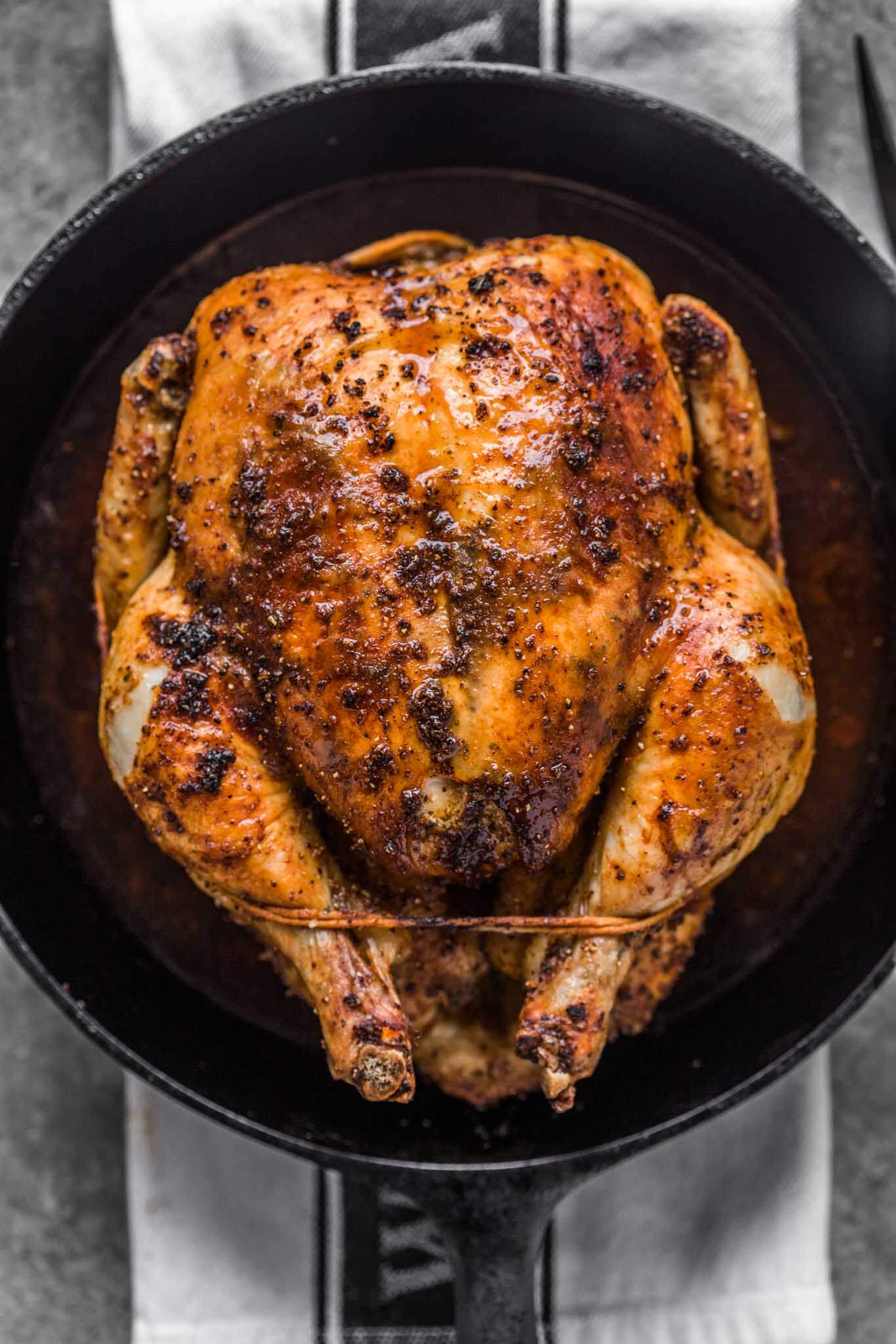 Overhead shot of roasted chicken in cast iron skillet.