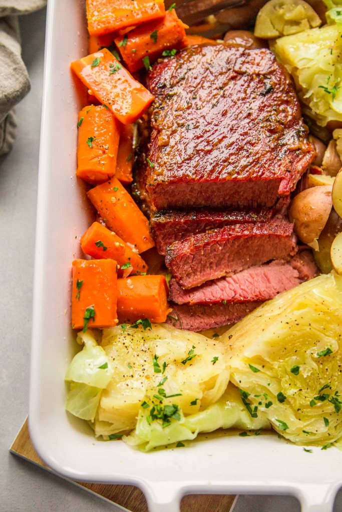 Instant Pot Corned Beef & Cabbage in a baking dish with carrots and potatoes