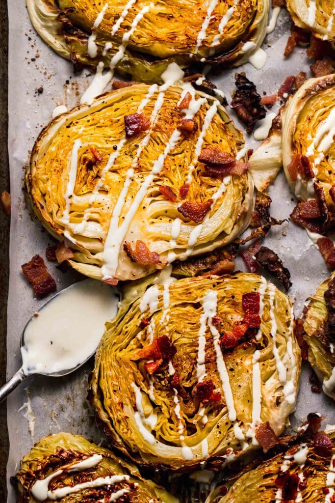 Baked cabbage steaks topped with bacon and drizzled with cream sauce.