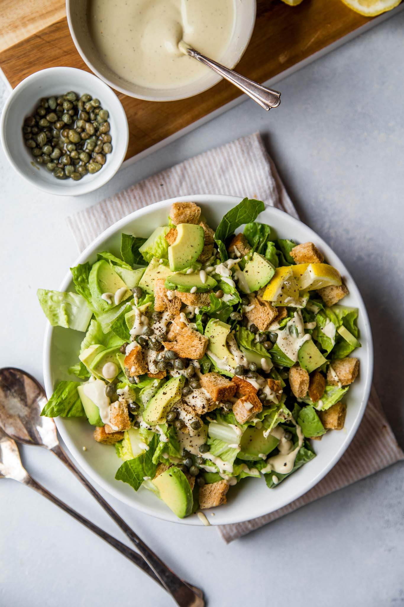 This Vegan Caesar Salad has all the tanginess and creaminess that you'd expect from a traditional Caesar salad, but it's completely plant based. Topped with fresh avocado, capers and croutons.