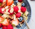 Overhead close up of bowl of oatmeal topped with berries and almonds.