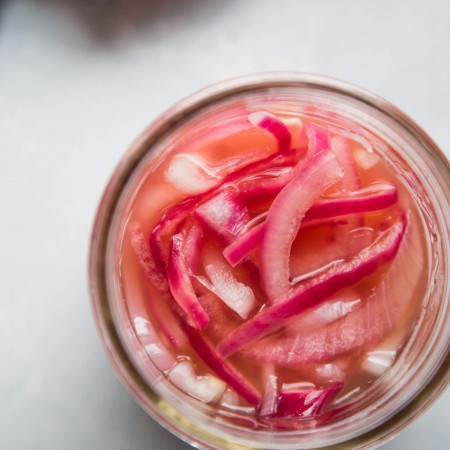 Overhead shot of quick pickled onions in mason jar.