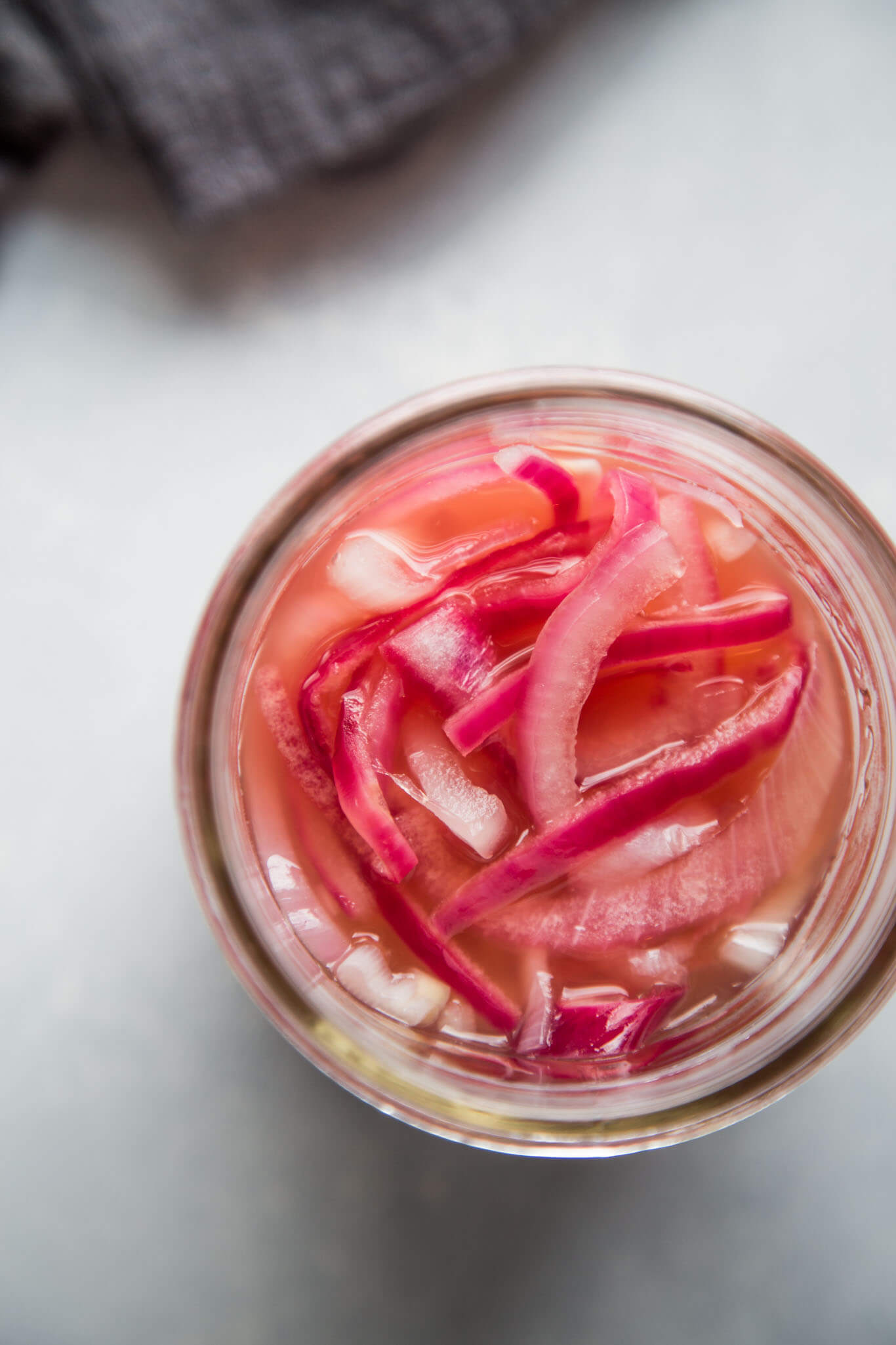 Overhead shot of quick pickled onions in mason jar.