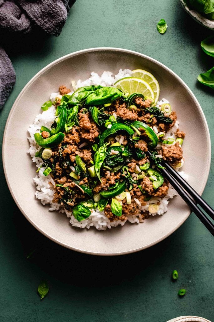 Thai basil beef in serving dish with chopsticks. 