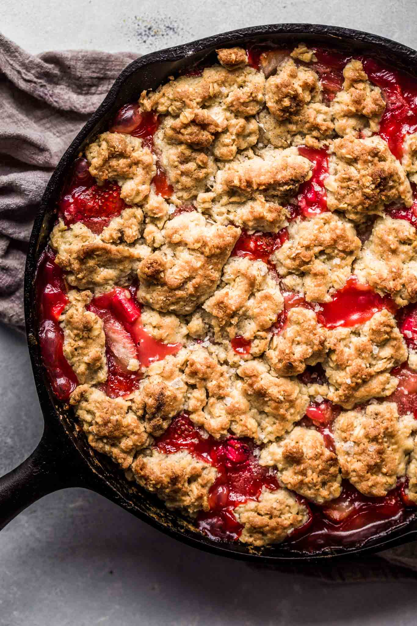 Cast iron strawberry rhubarb cobbler straight out of oven in cast iron skillet 