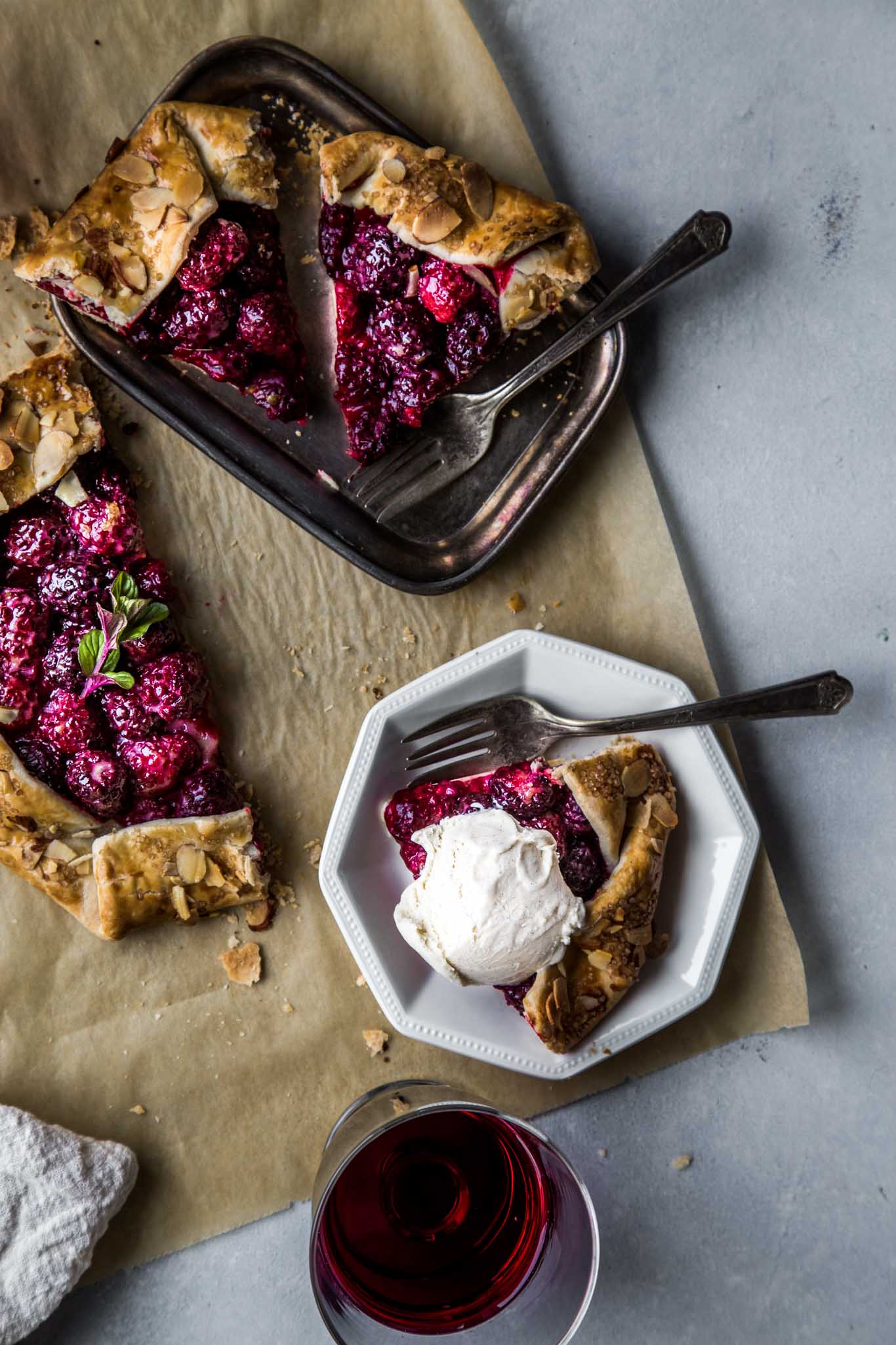 Overhead shot of blackberry galette sliced up and topped with ice cream.