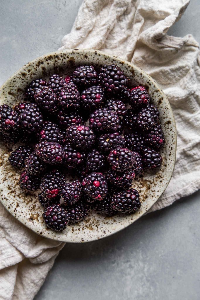 Blackberries in speckled bowl.