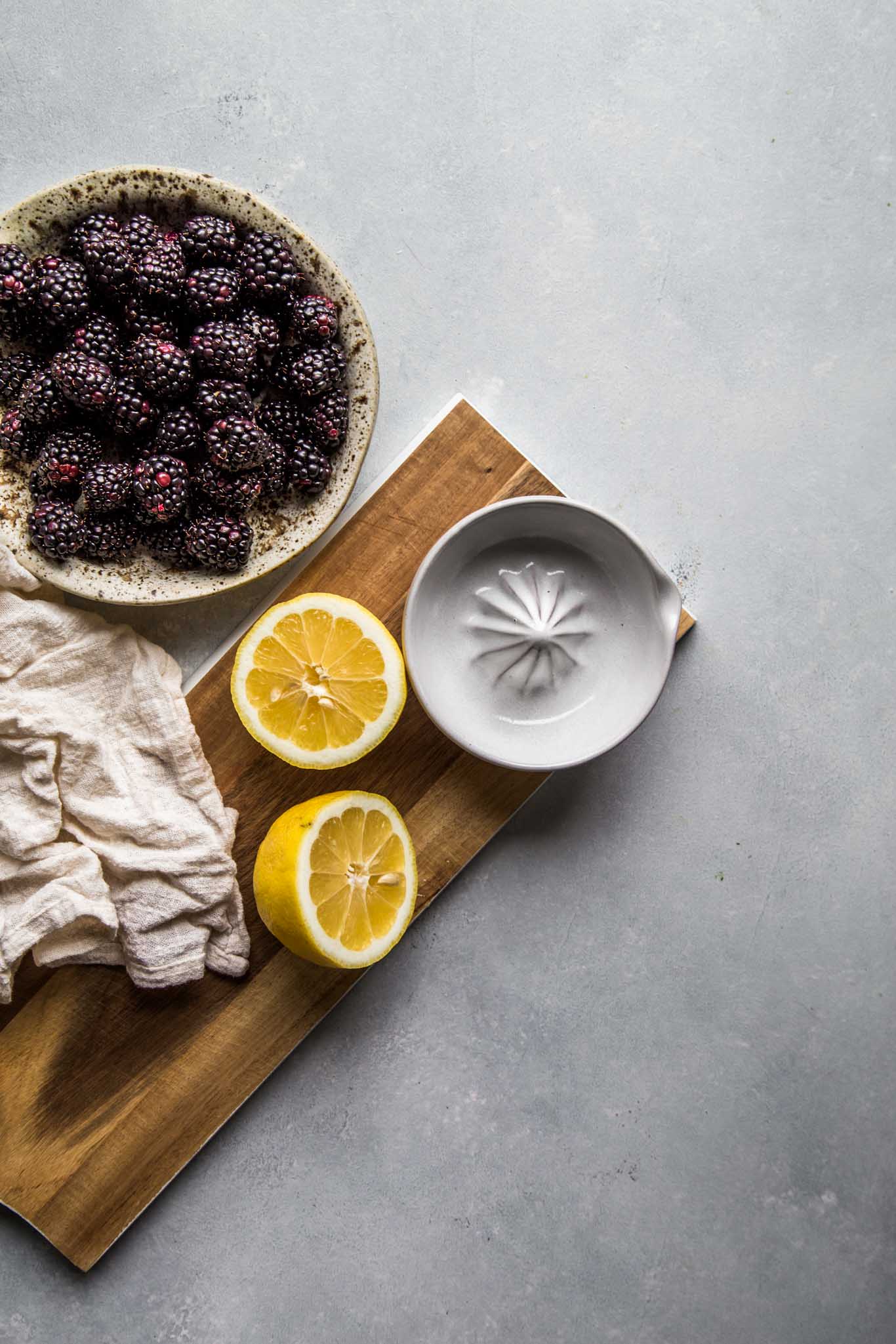 Ingredients for blackberry galette - blackberries and lemon on cutting board.