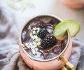 Close up of blackberry moscow mule topped with elderflowers