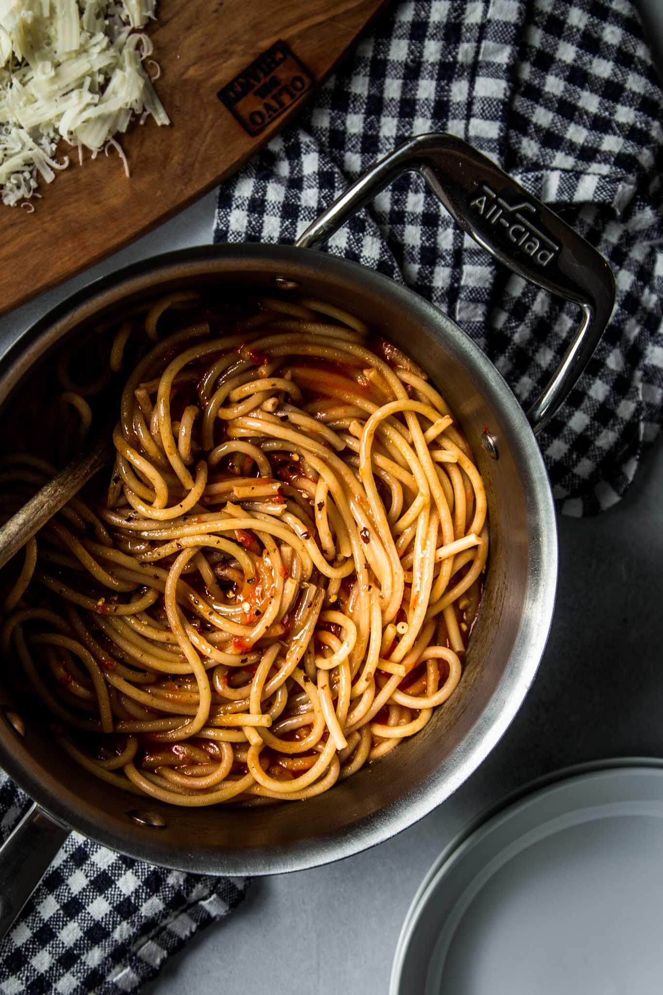 Pasta in pot tossed with tomato sauce.