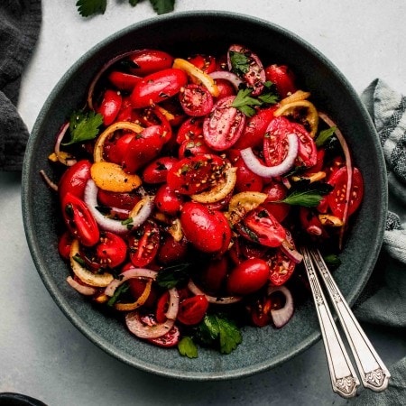 Overhead shot of cherry tomato salad in grey bowl.