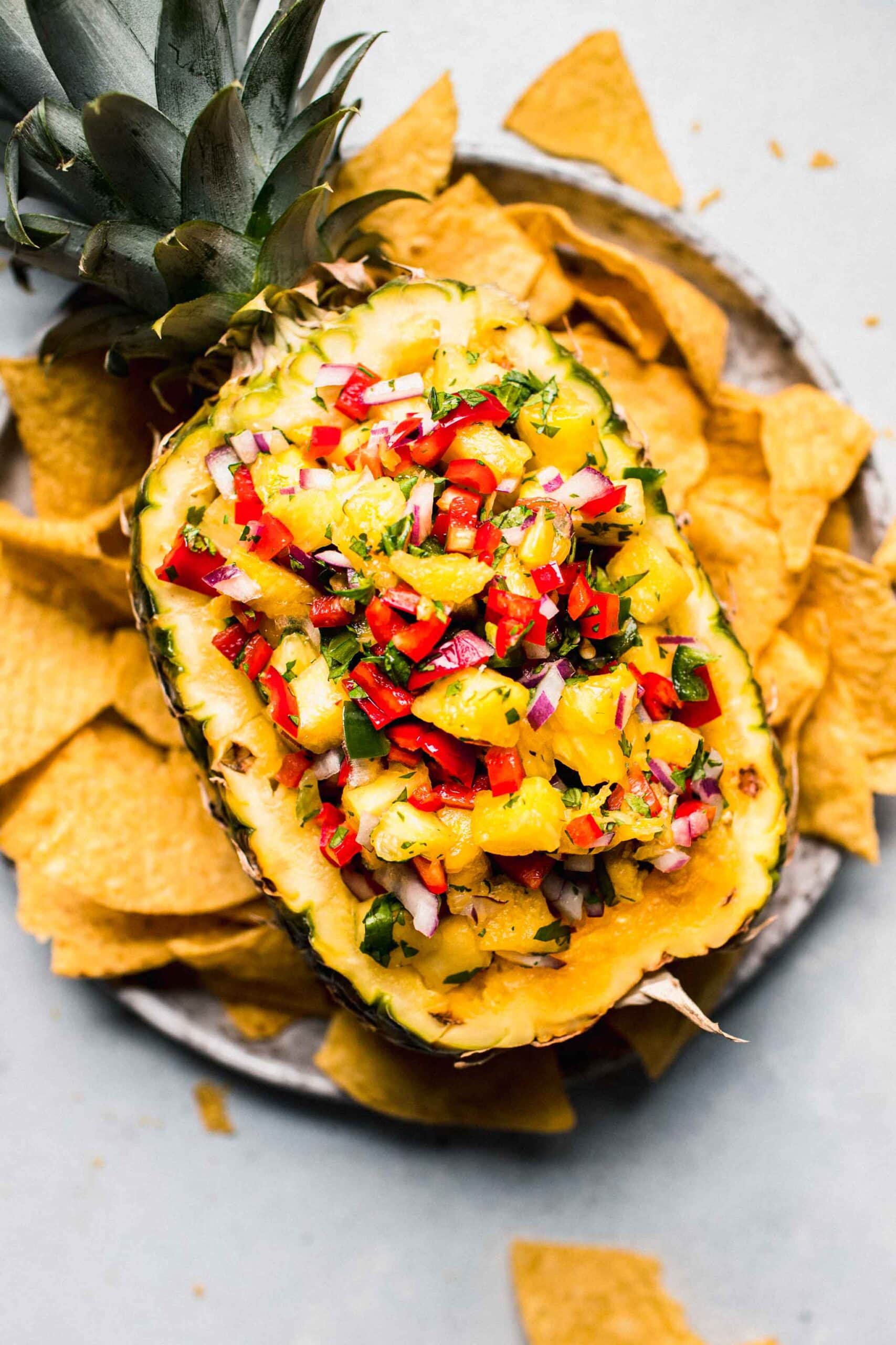 Pineapple salsa served in pineapple bowl next to chips.