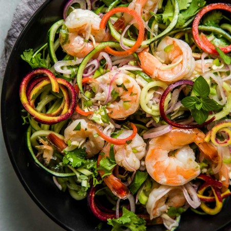 Overhead shot of thai shrimp salad on black plate.