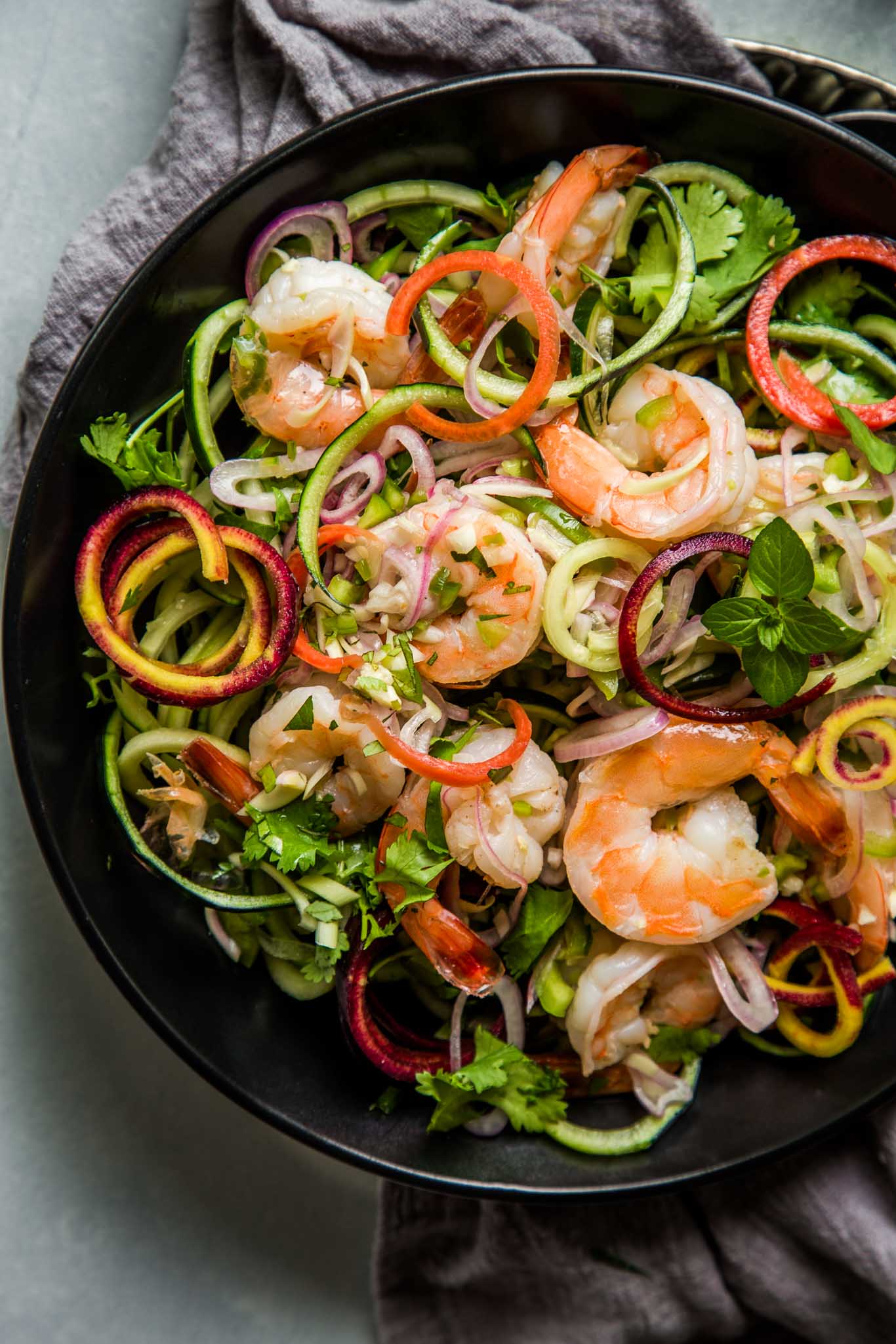 Overhead shot of thai shrimp salad on black plate.