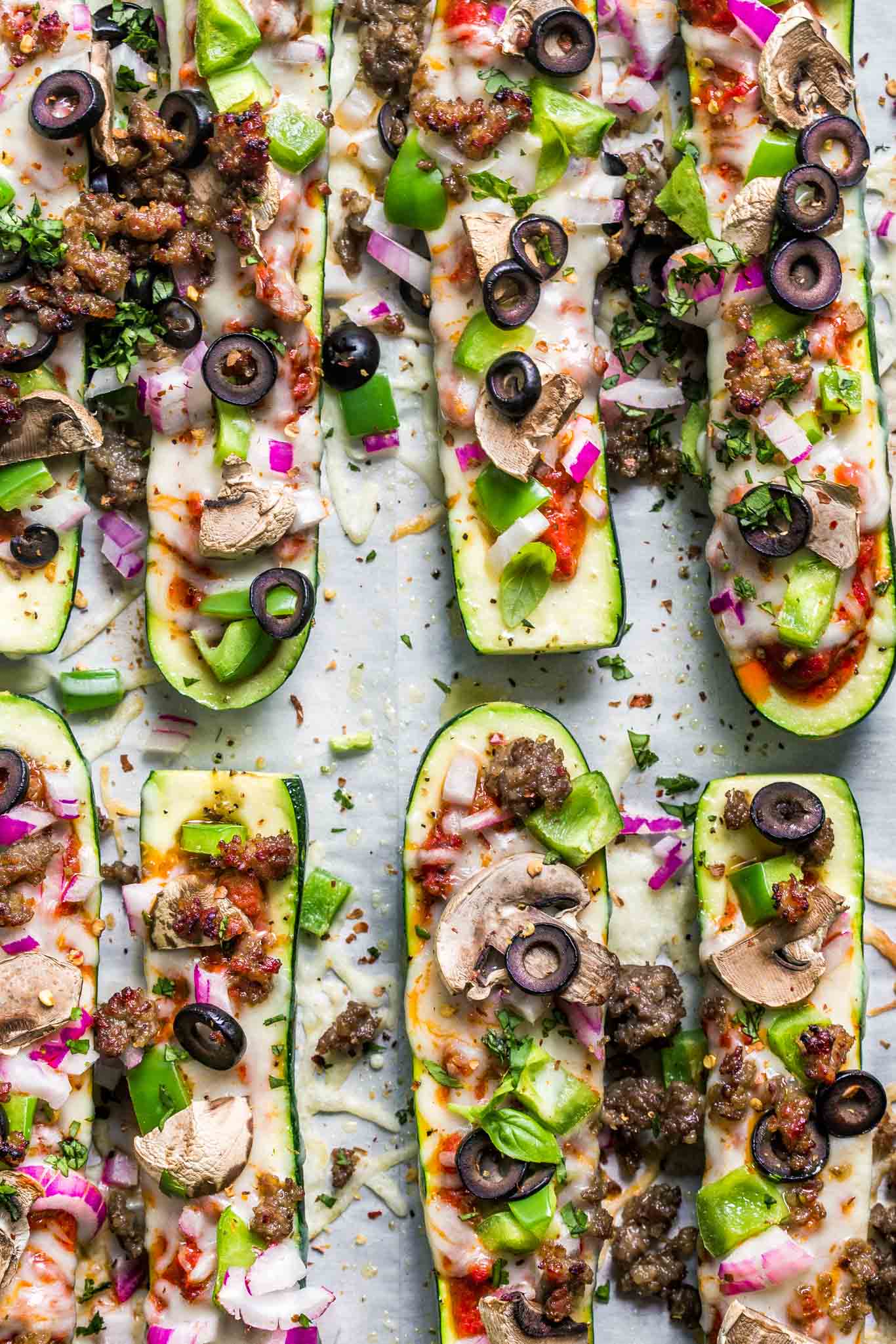 Overhead shot of zucchini pizza boats with supreme toppings.