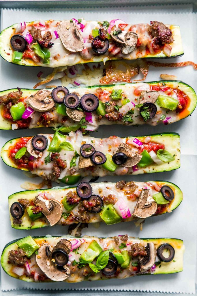 Overhead shot of zucchini pizza boats with supreme toppings.