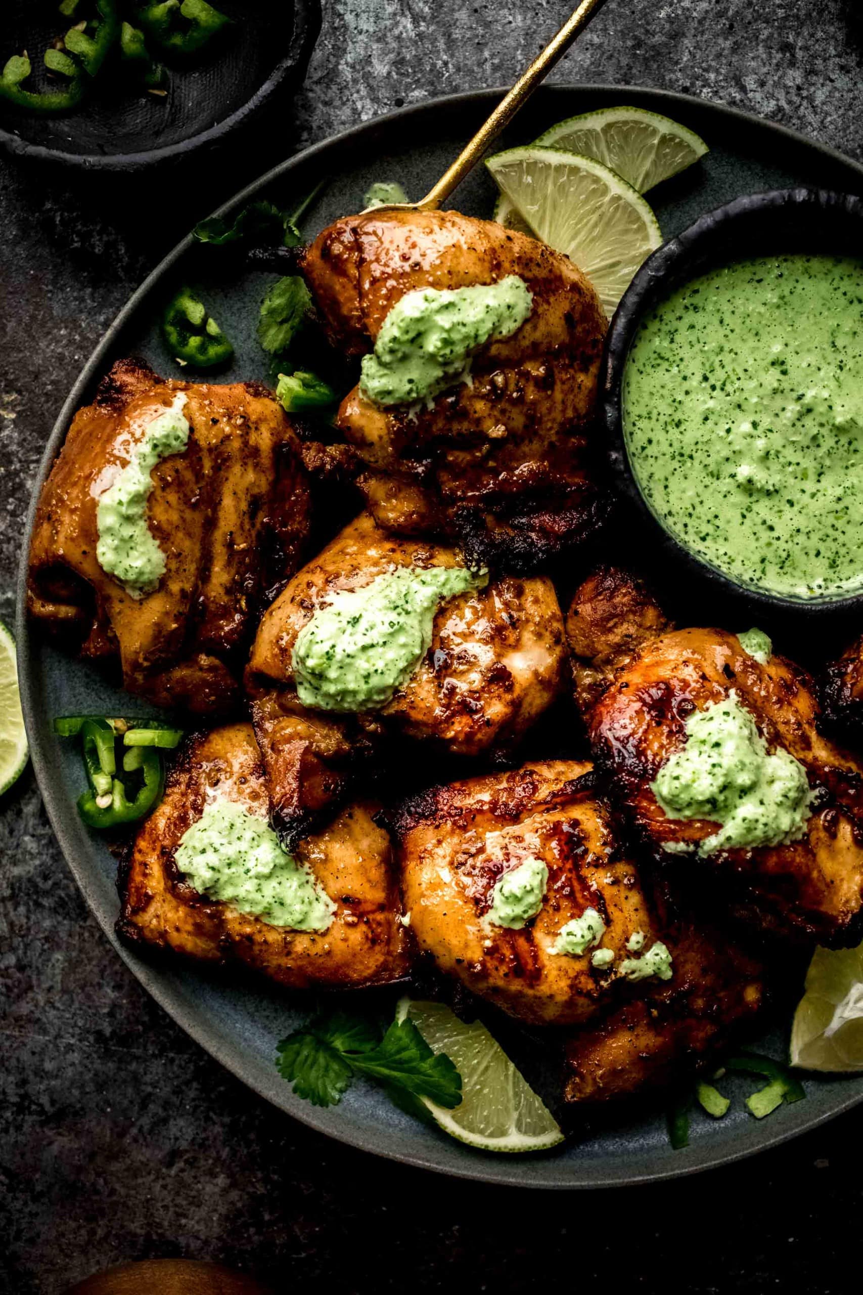 Plate of chicken drizzled with creamy green sauce.