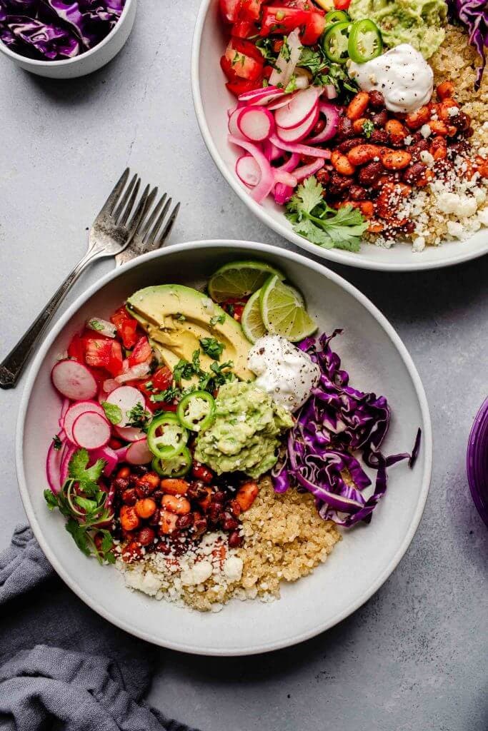 Two quinoa burrito bowls arranged on counter.
